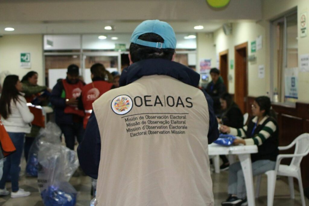 Veedor de la OEA en una sala de votación asegurando el correcto proceso eleccionario.