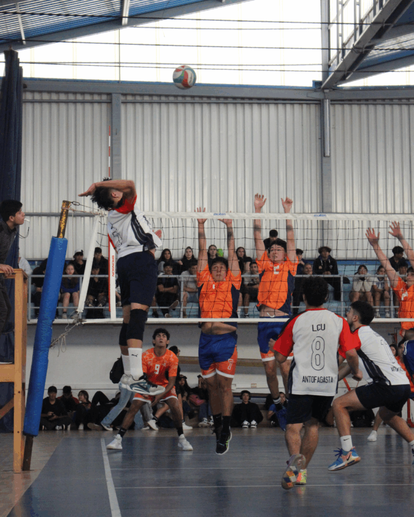 Jugador de la Universidad Católica del Norte preparando un remache para anotar un punto.